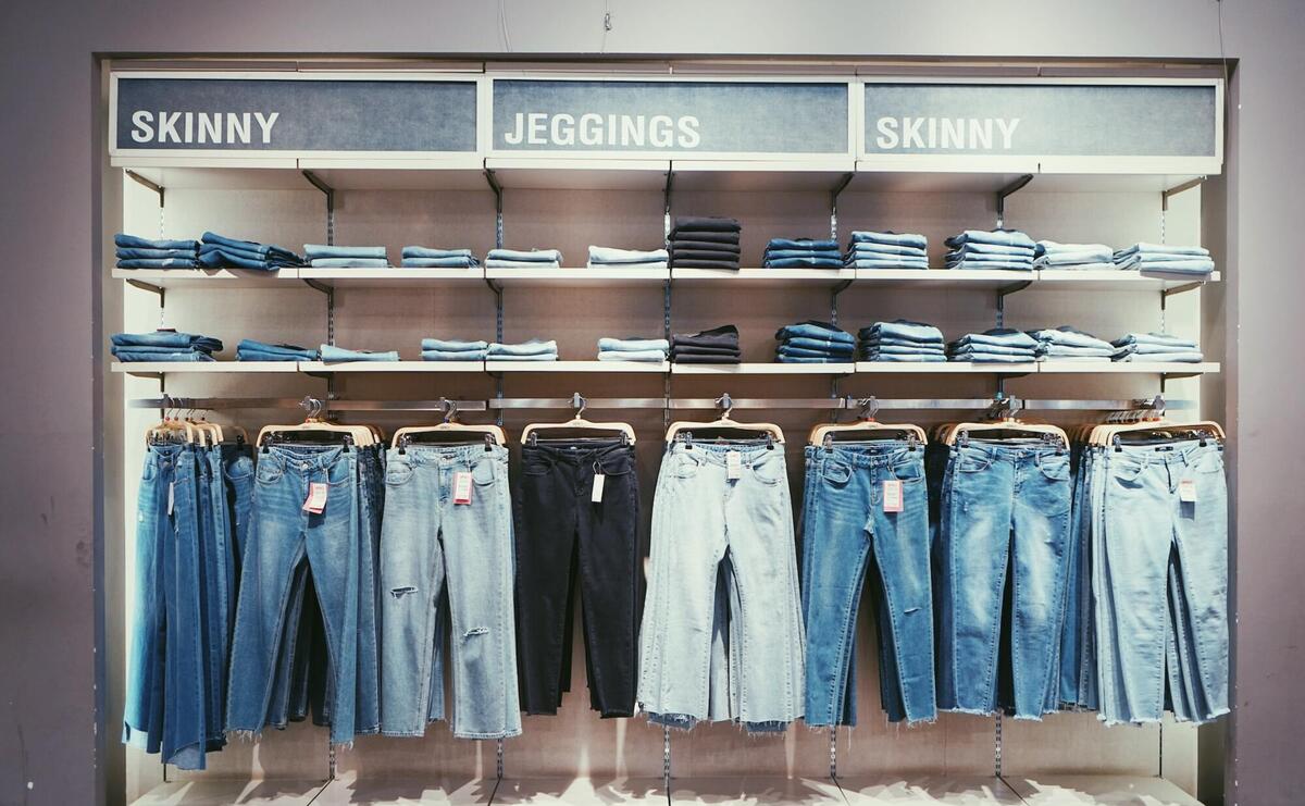 Different type of jeans hanging on hangers.