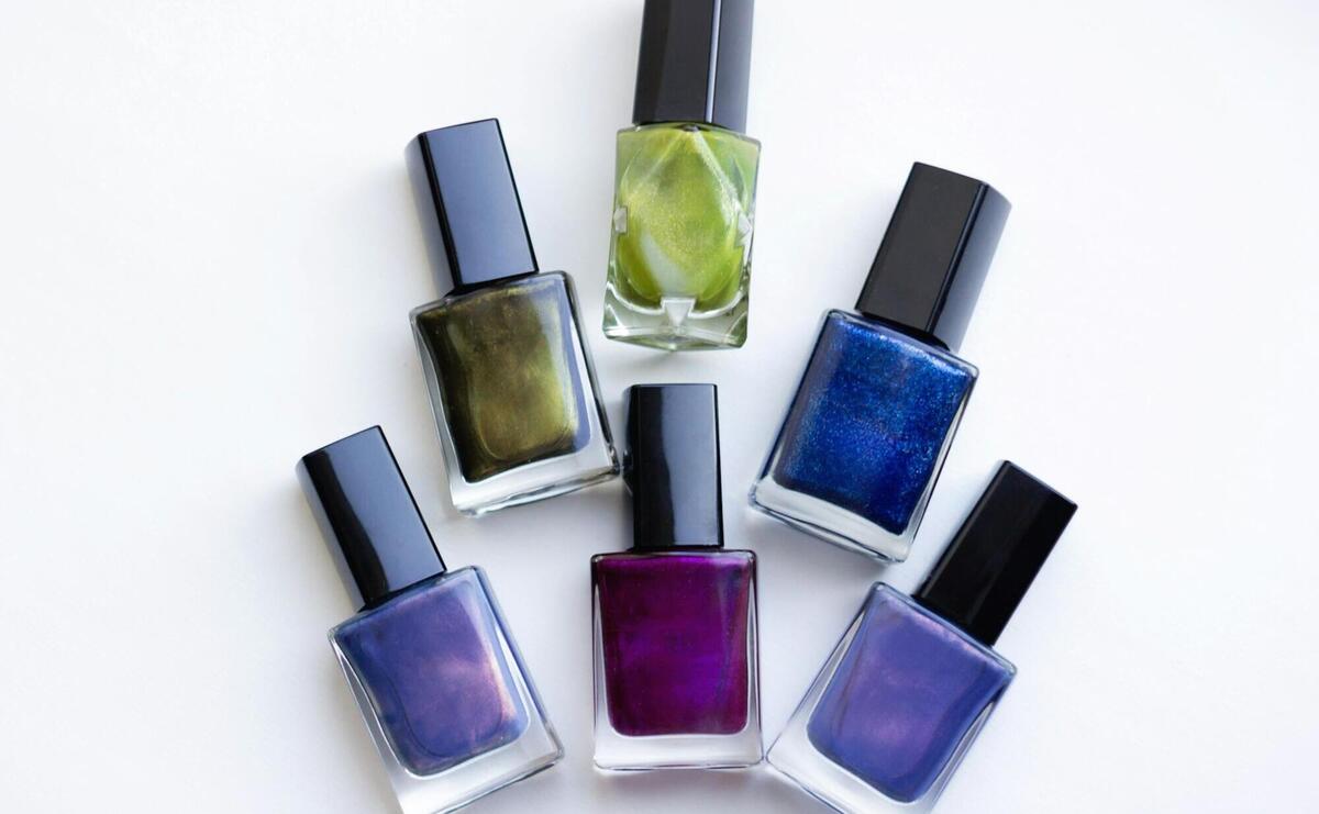 a group of five different colored nail polishes