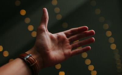 A persons hand with the palm facing towards the camera.