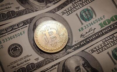 A bitcoin on a dollar note.