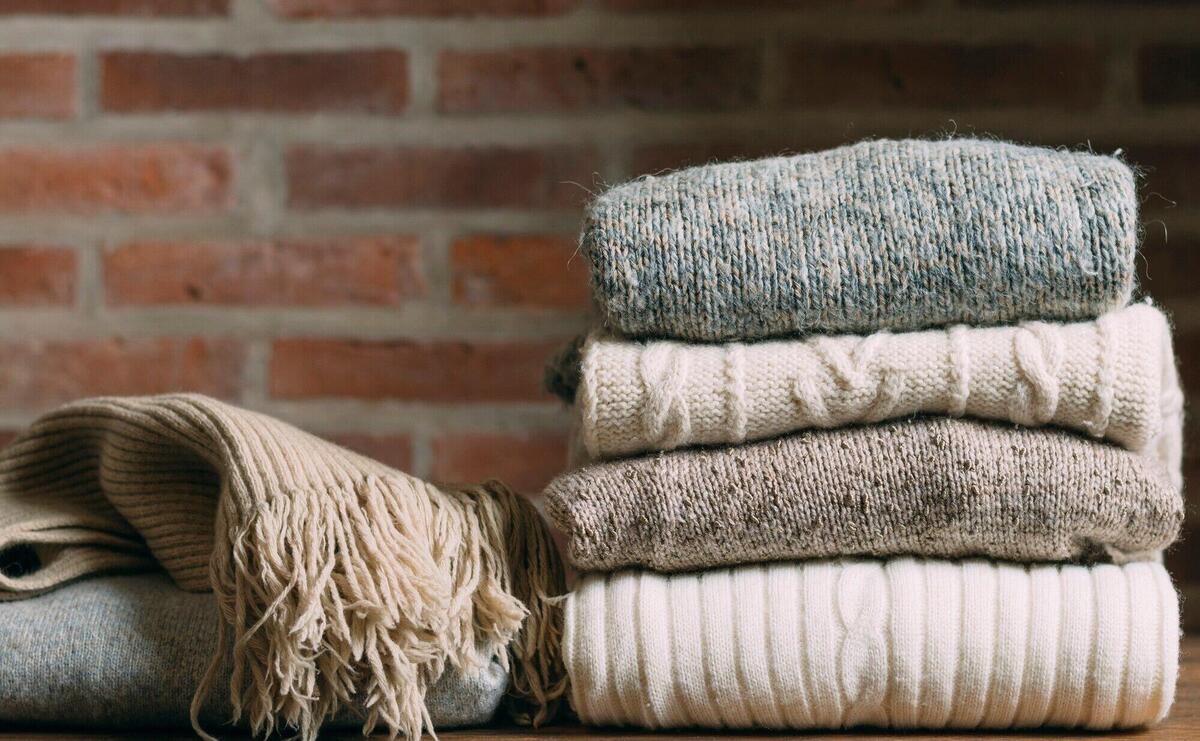 Arrangement with warm clothes and brick wall