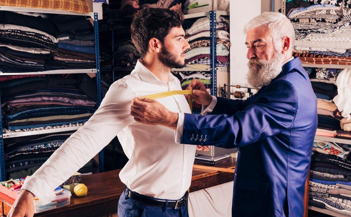 Professional male fashion designer taking measurement of his customer's chest