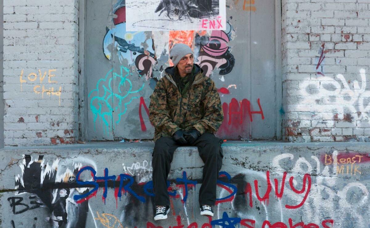 Man sitting on the wall full of graffiti