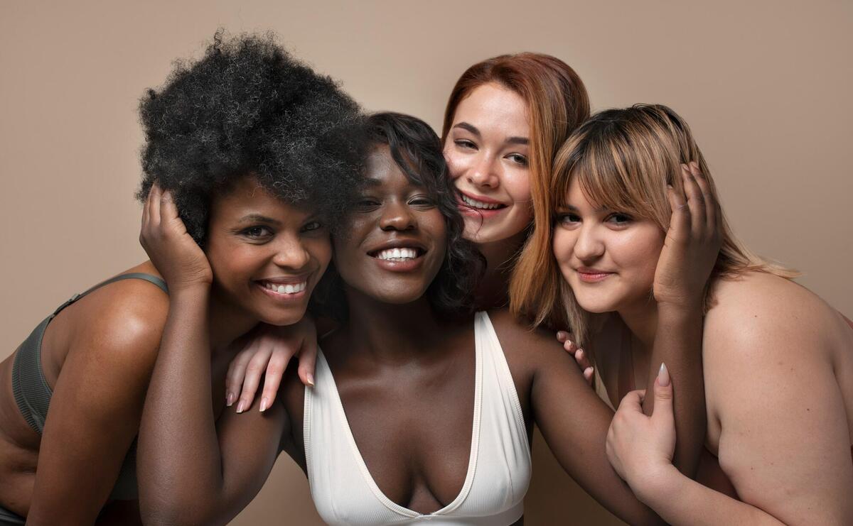 Smiling women with different tones of skin.